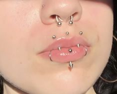 a woman with piercings on her nose and tongue