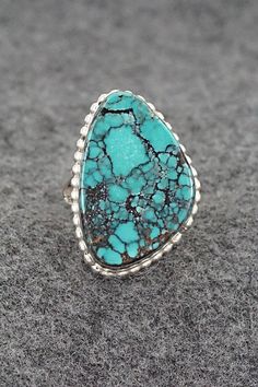 This turquoise and sterling silver ring was made by Navajo silversmith Larry Castillo. The back is signed LC and stamped sterling.Size: 7Length: 1 1/8"Width: 3/4"Free shipping on all orders! We ship with USPS and always include tracking. All orders ship within a day of payment.Returns are accepted up to 30 days after you receive your order. Just send us a message. Our shop offers cash back or store credit. The item must be returned in new condition. Southwestern Sterling Silver Turquoise Ring For Anniversary, Western Green Turquoise Ring In Sterling Silver, Western Style Turquoise Sterling Silver Ring, Southwestern Style Turquoise Gemstone Ring In Sterling Silver, Southwestern Turquoise Ring In Sterling Silver, Untreated Southwestern Turquoise Sterling Silver Ring, Southwestern Untreated Turquoise Sterling Silver Ring, Western Turquoise Ring With Inlay, Western Style Turquoise Ring With Inlay