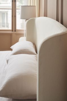 a white couch sitting next to a window in a bedroom