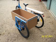 a blue bicycle with a brown box on the back