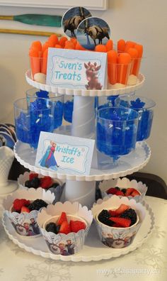 there is a tiered tray with cupcakes and fruit on it