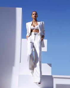 a woman in white is standing on some steps