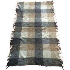 a plaid rug with fringes on the top and bottom, against a white background