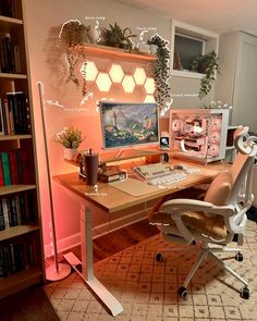 a desk with a computer on it in front of a bookshelf