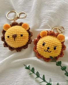 two crocheted keychains with lions on them sitting next to each other