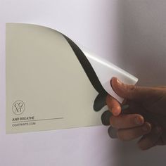 a hand holding a white and black business card