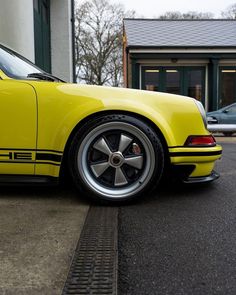 a yellow sports car parked in front of a building