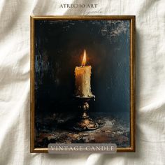 a lit candle sitting on top of a table next to a white cloth covered wall