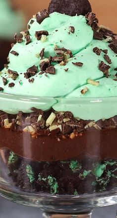 a chocolate cake with mint green frosting and cookies on top in a glass dish