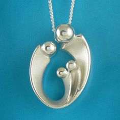 "Mom of three mother's pendant may otherwise be interpreted as celebrating your loving family of four! Our expressive, egg-shaped creation is hand sculpted in sterling silver. Size: 1\" X 5/8\": $158. Bright polished heads and raised curves are contrasted with recessed contours that have a soft satin finish. Fully finished reverse. This richly dimensional pendant includes a sterling chain that threads through the design's integrated and invisible chain bail. The included US-made 1.2mm curb link Sterling Silver Oval Pendant Necklace As Gift For Mom, Oval Large Pendant Jewelry For Anniversary, Oval Necklaces For Anniversary And Mother's Day, Sterling Silver Oval Necklace For Mom, Oval Sterling Silver Necklace For Mom, Anniversary Necklace With Large Oval Pendant, Unique Jewelry For Mother's Day Gift, Sterling Silver Necklace With Polished Finish For Mother's Day, Mother's Day Polished Sterling Silver Necklaces