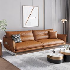 a brown leather couch sitting in a living room on top of a white rug next to a coffee table