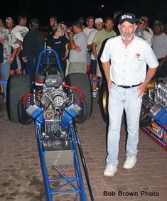 a man standing in front of some racing cars