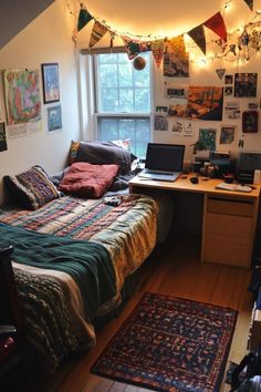 a bedroom with a bed, desk and laptop on it