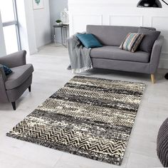 a living room with two chairs and a rug on the floor