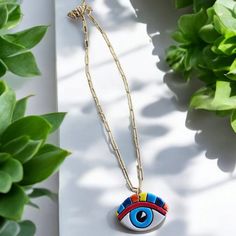 Introduce a splash of color and symbolism to your jewelry collection with our Stainless Steel Chain Necklace featuring a Handmade Ceramic Rainbow Eye Pendant. This striking necklace showcases a beautifully crafted ceramic eye, meticulously handmade and painted with vibrant rainbow colors. Each piece is unique, making it a truly special addition to any wardrobe. The eye pendant, a symbol of protection and positive energy, is delicately suspended from a sleek stainless steel chain. The chain's durable and hypoallergenic properties ensure that this necklace is both stylish and comfortable for everyday wear. This necklace is perfect for adding a bold statement to your look, whether you're dressing up for a special occasion or adding a touch of flair to your casual attire. The combination of th