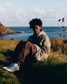 a person sitting on the ground near some water