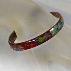 This vintage cloisonne bracelet is really gorgeous!  It features a glazed brown bangle with Chinese cloisonne in turquoise, blue, green, gold and red flowers and leaves.   A perfect addition to your vintage jewelry collection!Size:  7-1/2, 1/3" widthApproximate Date:   1970s Hallmarks/signature:   None.Condition:  ExcellentColors:Blue, Red, Green, Brown, Turquoise, GoldStyle:   70s Jewelry, Retro, Mod, Cloisonne JewelryFor more vintage treasures, please visit my shop at waalaa.etsy.com vintage j Adjustable Round Enamel Bracelets, Adjustable Enamel Bangle For Gift, Adjustable Enamel Bangle As Gift, Adjustable Enamel Bangle As A Gift, Multicolor Hand Painted Bangle Jewelry, Hand Painted Multicolor Bangle Jewelry, Vintage Hand Painted Brown Jewelry, Hand Painted Brown Vintage Jewelry, Vintage Brown Hand Painted Jewelry