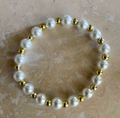 White pearl bracelet with gold beads. Stretch bracelet. 7-1/4 inch, One size will fit most..Message me If smaller or larger size is needed! Handmade to order. Free shipping on all orders. Cheap White Beaded Bracelets With Spacer Beads, Cheap Beaded Pearl White Stretch Bracelet, Affordable White Stretch Bracelet With Spacer Beads, Affordable White Bracelets With Gold Beads, Cheap White Bracelets With Gold Beads, Cheap White Stretch Bracelet With Gold Beads, Gold Stretch Bracelet, White Pearl Bracelet, Ball Bracelet