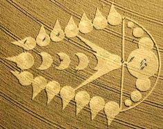 an aerial view of a clock in the middle of a field, with arrows drawn on it