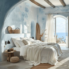 a bedroom with blue walls and white bedding has an arched window overlooking the ocean