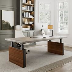 a desk with a laptop on it in front of a bookshelf