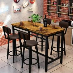 a kitchen table with four stools next to a brick wall