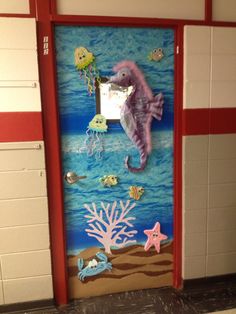 a door decorated with sea animals and corals on the side of a school hallway