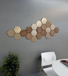 a white chair sitting in front of a wall with wooden hexagonals on it