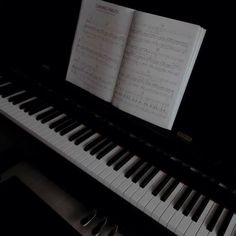 an open book sitting on top of a piano