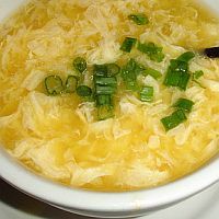 a white bowl filled with soup on top of a wooden table