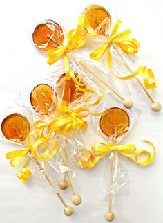 candy lollipops wrapped in cellophane and tied with yellow ribbon on white background