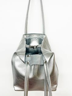 DESCRIPTION:Genuine leather tote bag, great for your essentials when you want a compact bag. Use around town for the weekend or an everyday bag. Perfect for travel as the bottom folds to pack flat.• Genuine leather with a metallic silver finish • Zipper closure OR Swivel lobster clasp and D-ring for closure• Interior pocket• Double leather strap with rivet detail• Reinforced leather bottom • Unlined with raw edges• Fringe detail on strap• Hand made• Made in USADIMENSIONS:9.5”H x 8”W x 4.5”D9.5" Cleaning Leather, Bag Packs, Travel Free, Compact Bag, Genuine Leather Totes, Side To Side, Keychain Wallet, Tassel Keychain, Silver Zipper