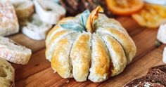 breads and pastries on a cutting board with dried oranges in the background