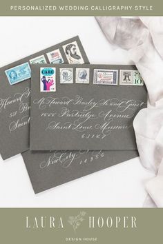 two envelopes with stamps on them sitting next to each other