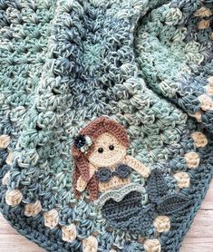 there is a crocheted blanket with a little mermaid on the front and bottom