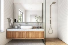 a bathroom with a sink, mirror and shower stall in it's center area