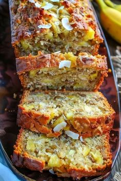 sliced loaf of banana bread sitting on top of a plate next to bananas and other fruit