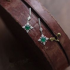 This danity green jade dangle earrings is very stunning and delicate. It's inspired by the shape of snowflake, and the vivid green jade make it unique and special among the snowflake earrings. It's a best gift idea for birthday gifts, engagement gifts, bridesmaid gifts and anniversary gifts. Features: - Made to Order - Material: 925 Sterling Silver with 14K Gold Plated - Color: White Gold - Stone: Natural Green Jade & CZ - Ready to ship in 8 to 12 business days - Each order will be beautifully packaged for gift giving in a jewelry box. Thank you for your time on our store. Hope you like our designs. Find out more about us on: https://www.etsy.com/hk-en/shop/SusannaJewelryDesignReturn and Refund: We don't accept return and refund for solid gold orders and custom orders except for quality pr Luxury Silver Jade Earrings, Elegant Round Emerald Earrings, Fine Jewelry Green Drop Earrings, Green Fine Jewelry Drop Earrings, Green Sterling Silver Single Earring, Green Crystal Earrings For Pierced Ears, Elegant Green Crystal Earrings For Pierced Ears, Elegant Jade Earrings For May Birthstone, Elegant Green Sterling Silver Earrings