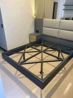 a bed frame in the middle of a room with mirrors on the wall and floor