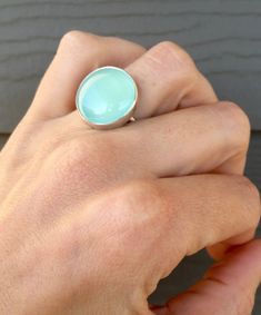 A lovely round blush pink or aqua blue chalcedony has been set in sterling silver and is framed by an elegant scallop setting. The ring band has been handmade from sterling silver half dome wire. The chalcedony is 20mm in size. The ring is chic and easy to wear with any outfit! Also available in a simple plain setting, see photo three in both stone colors! Made to order! Pink Chalcedony, Blue Or Pink, Ring Blue, Blue Chalcedony, Half Dome, Ring Band, Blue Rings, Aqua Blue, Sterling Silver Ring