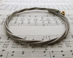 Recycled Bass Guitar String Bracelet silver colored with brass | Etsy Music Scholarships, Repurposed Piano, Guitar String Bracelet, Musician Gifts, Guitar Strings, Learn Guitar, String Bracelet, Music Lover, Bracelet Silver