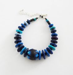 a blue and black beaded necklace on a white background