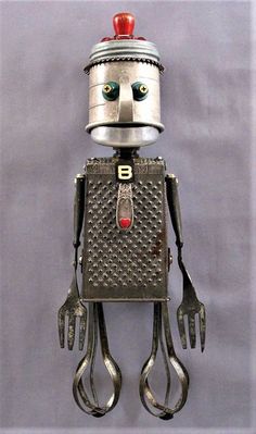 a robot made out of metal with scissors attached to it's head and eyes