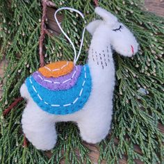 a white llama ornament hanging from a tree