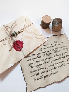 a piece of paper with writing on it next to two corks and a wax stamp