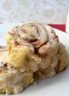 two cinnamon rolls sitting on top of a white plate