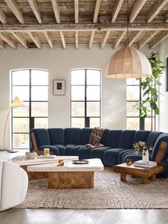 a living room filled with lots of furniture and large windows in the wall behind it