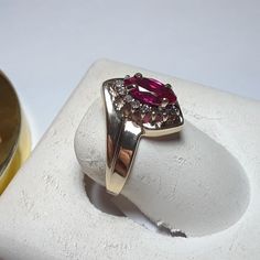 This Bright Ring Features A 8x4mm Marquise Cut Lab Ruby, Set With 4 Secure Prongs On A Halo Head. There Are 14 Natural Round White Diamonds Forming The Halo Around The Ruby. The Setting Is High Polished With A Step Down Offset Design, Aprox 1/2" In Width At The Center And Weighs Aprox 2.498 Grams Of Solid (Stamped 10kt & Gtr) 10kt Yellow Gold. This Bright Lab Ruby & Diamond Ring Has A Msrp Of $2819.00. Finger Size 7 (This Ring Can Be Sized By Your Local Jeweler, At Your Cost, We Do Not Size) Classic Marquise Ruby Ring With Vvs Clarity, Classic Ruby Diamond Ring Stamped 14k, Marquise Ruby Ring With Prong Setting In 14k Gold, Marquise Ruby Ring With Diamond Accents In Yellow Gold, Classic Yellow Gold Ruby Ring With Marquise Cut, Yellow Gold Ruby Ring With Prong Setting, Classic Marquise Cut Ruby Ring In Yellow Gold, 14k Gold Marquise Cut Ruby Ring With Prong Setting, Classic Yellow Gold Marquise Cut Ruby Ring