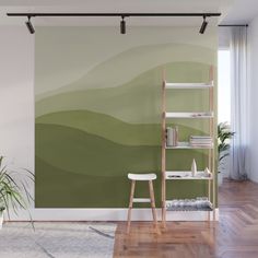 an abstract green and yellow wall mural in a living room with wooden flooring, bookshelf and shelves