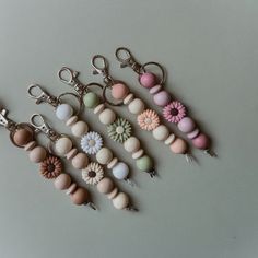 several key chains with flowers on them are arranged next to each other in different colors